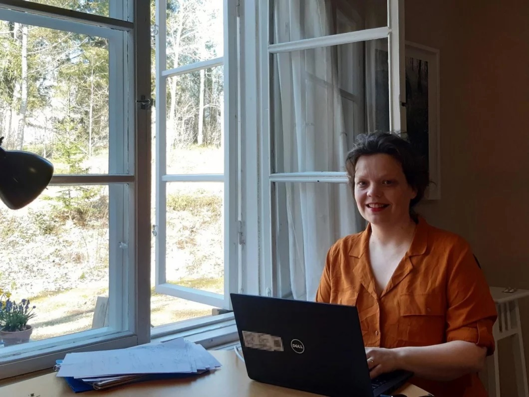 FT Salome Tuomaala-Özdemir istuu työpödän ääressä avoimen ikkunan edessä.